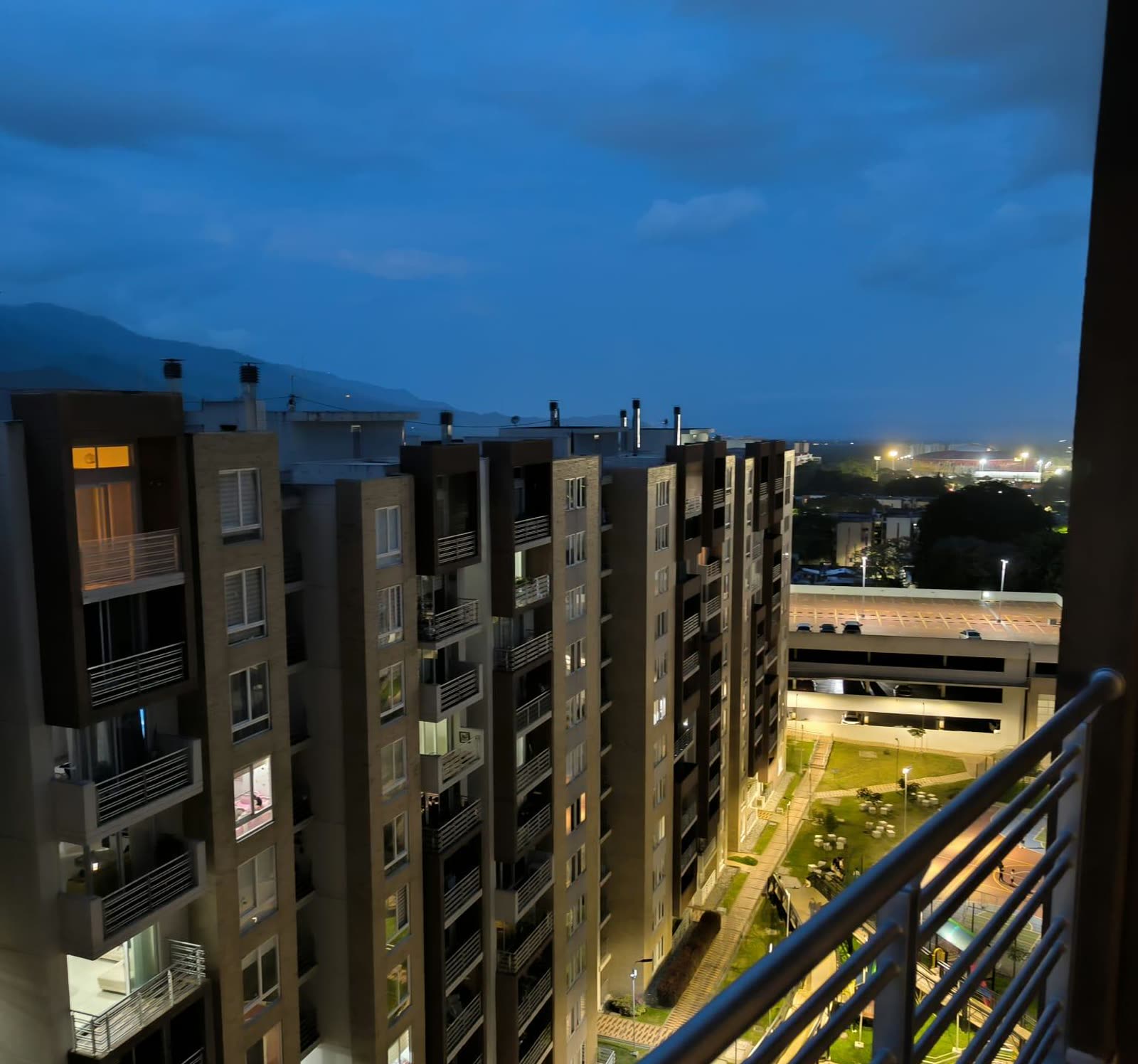 Vista nocturna de las torres del conjunto, parqueaderos y zonas verdes